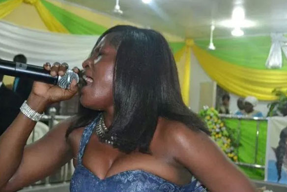 a fat black woman with white long dress singing in the church with her breasts exposed