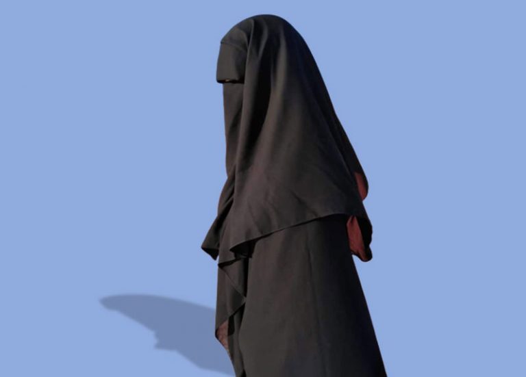 a man disguised in an abaya and niqab