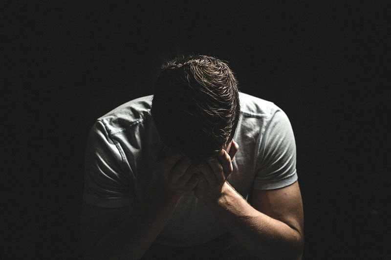 an angry man, sitting down in a pensive mood